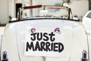 Close-up of "Just Married" sign attached on convertible car's trunk. Horizontal shot.